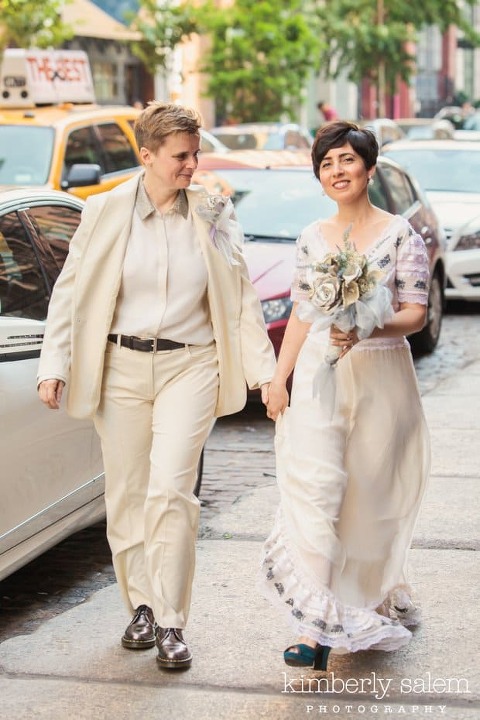 Brides walking along the sidewalk with NYC taxi in background